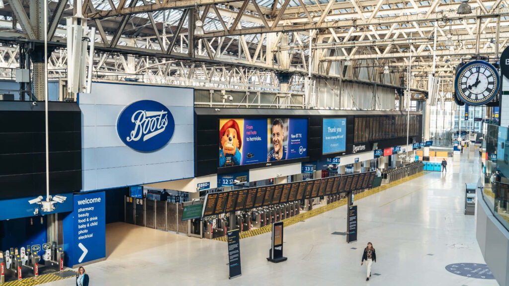 Digital Symphony at Waterloo Station: A Vibrant Wallpaper of Electronic Billboards and Signages