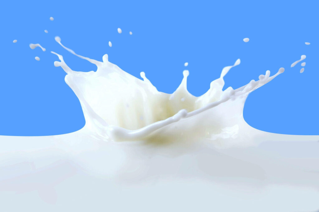 Elegant Milk Drop Splash Wallpaper on Bright Blue Background