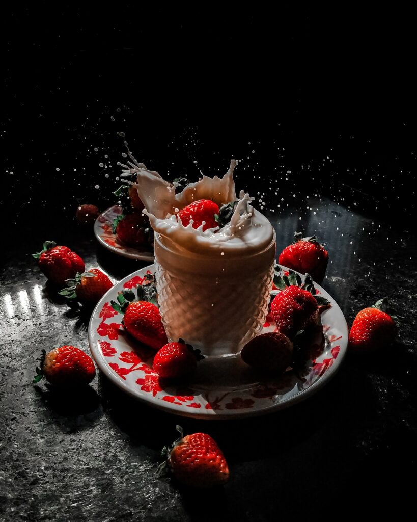 Vibrant Strawberry Splash with Milk: Artistic Dark Wallpaper