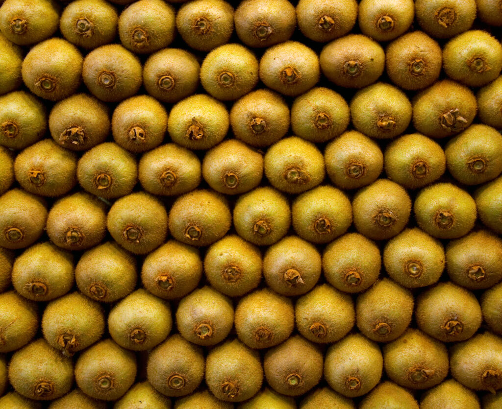 Vibrant Kiwi Fruit Wallpaper: Minimalistic Earthy Texture Design