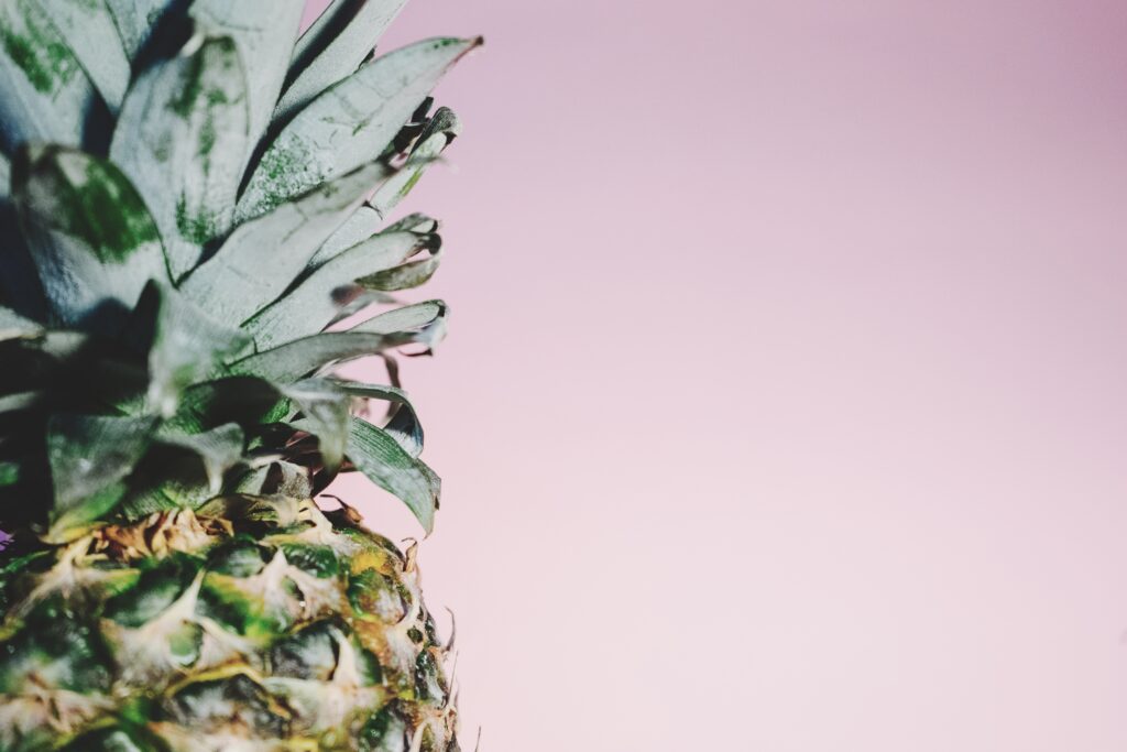 Vibrant Minimalist Pineapple Wallpaper on Soft Pink Background