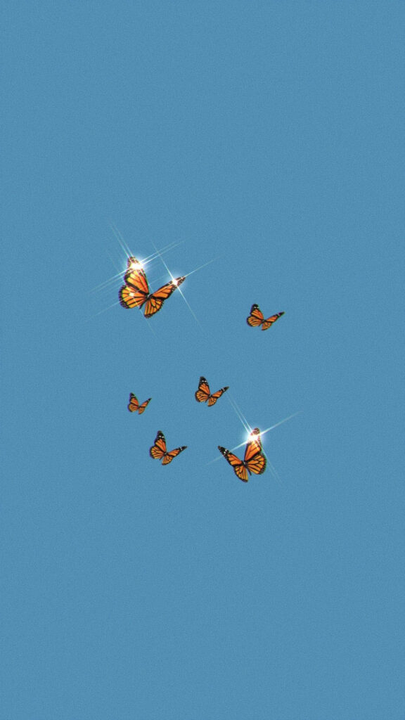 Vibrant Monarch Butterflies on Serene Blue Minimalist Wallpaper