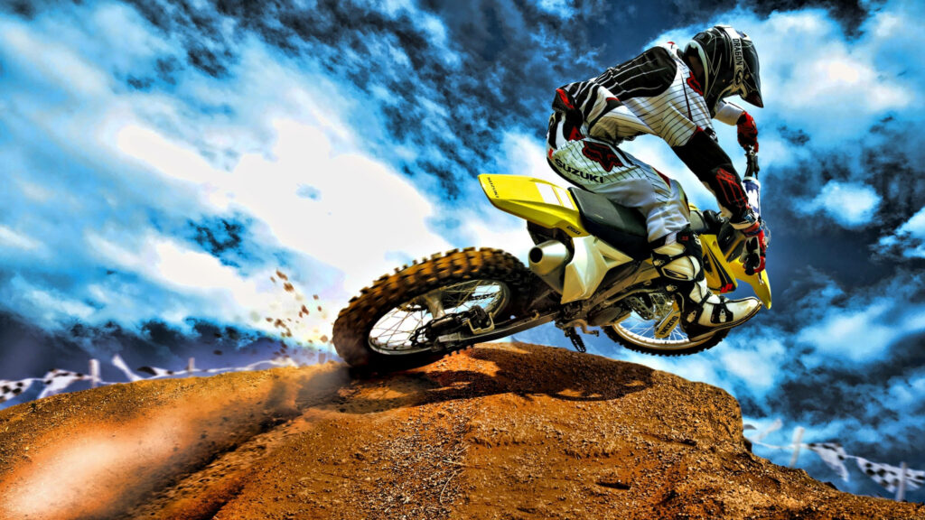Thrilling Motocross Wallpaper: Rider on Dirt Bike Under Blue Sky
