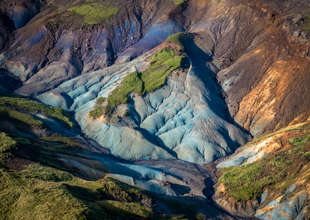 Colorful mountain slopes with rugged terrain and vibrant vegetation natural landscape wallpaper