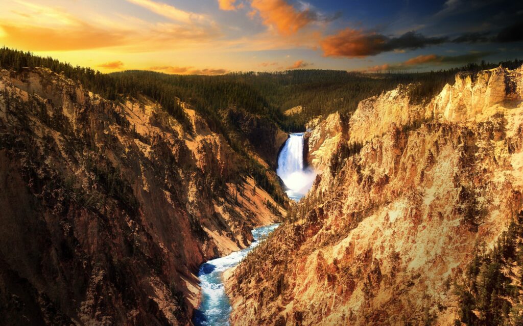 Vibrant river winding through rugged mountains with waterfall and dense forest under sunset sky Wallpaper