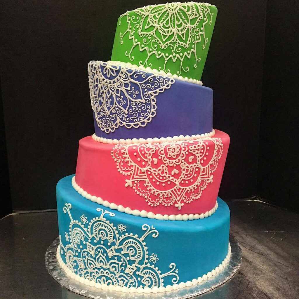 Multi-tiered wedding cake wallpaper with colorful layers and intricate white mandala patterns
