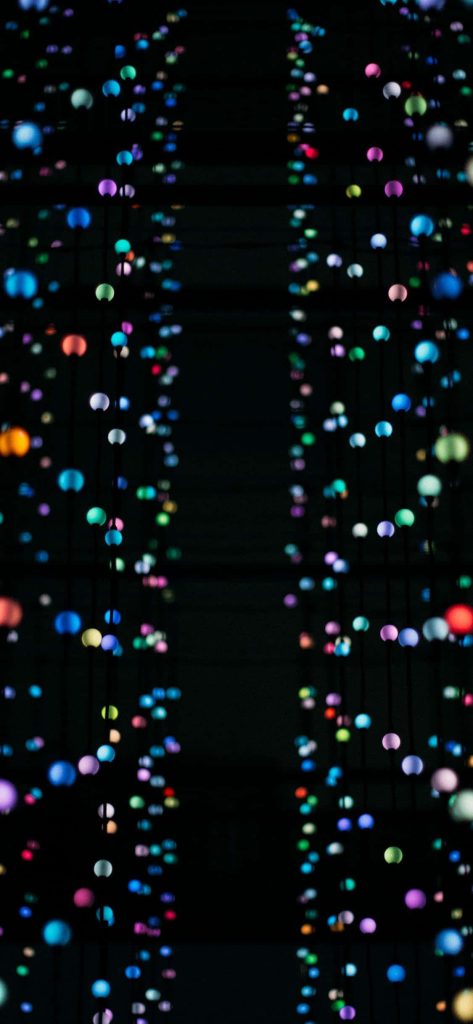 Vibrant multicolored glowing LED spheres wallpaper on black background for iPhone screen