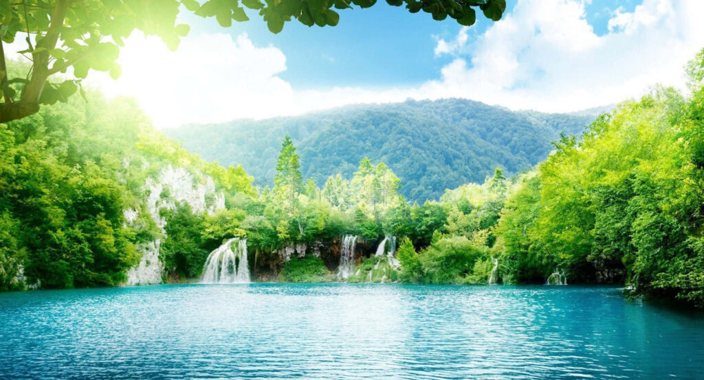 Tranquil Nature Wallpaper: Sunny Lake & Waterfalls in Vibrant Greenery