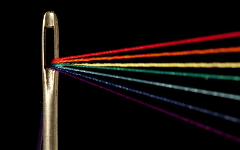 Vibrant Needle and Thread Close-Up: Artistic Dark Wallpaper