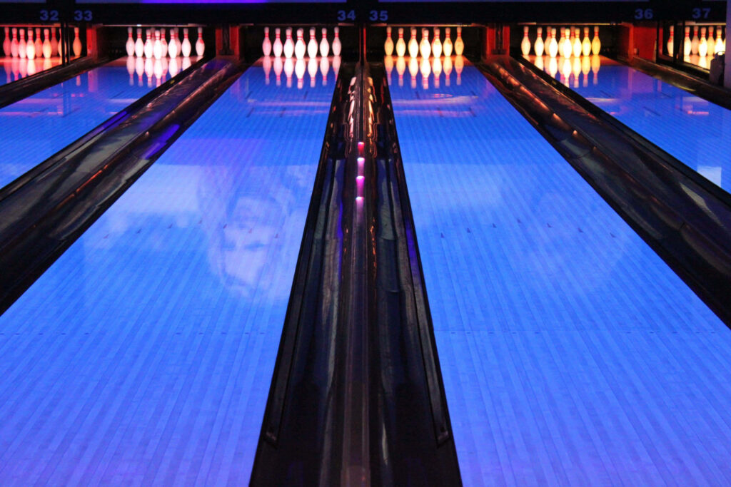 Vibrant neon bowling wallpaper with glossy lanes and perfect strike pins in dynamic perspective