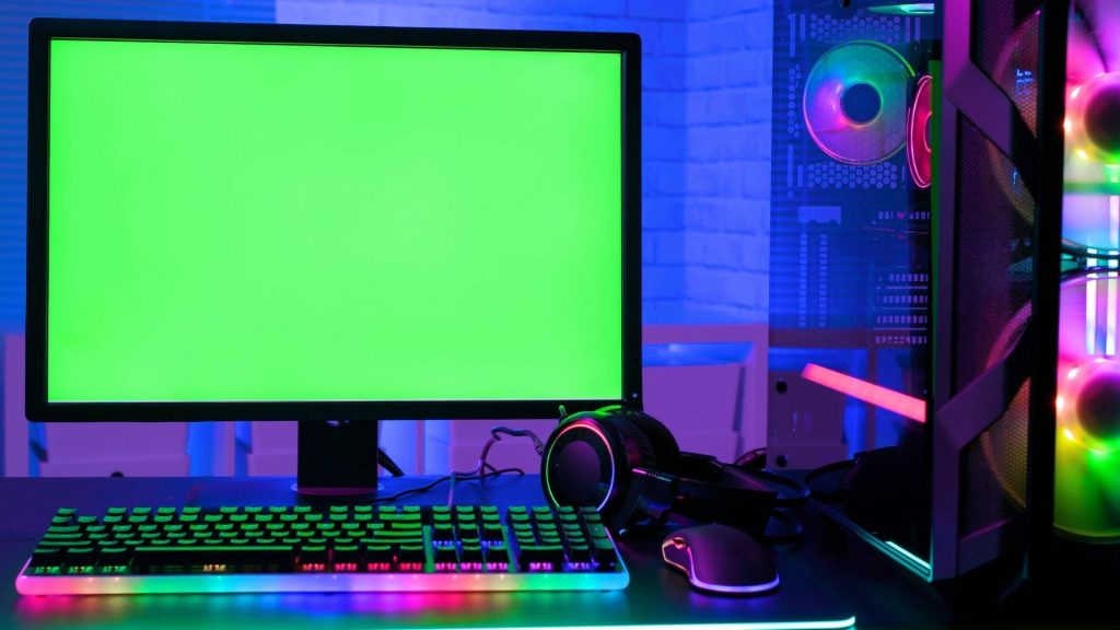 Vibrant gaming room wallpaper with green screen monitor PC tower RGB keyboard neon lighting