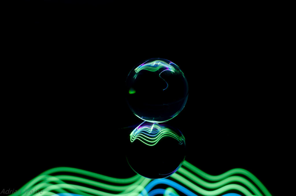 Stunning Reflective Glass Ball with Neon Lights on Black Background Wallpaper