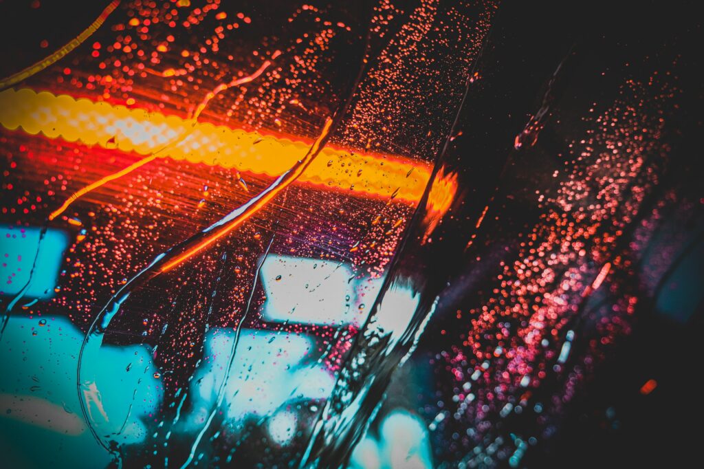 Neon Lights Wallpaper: Dynamic Reflections on Rain-Streaked Glass