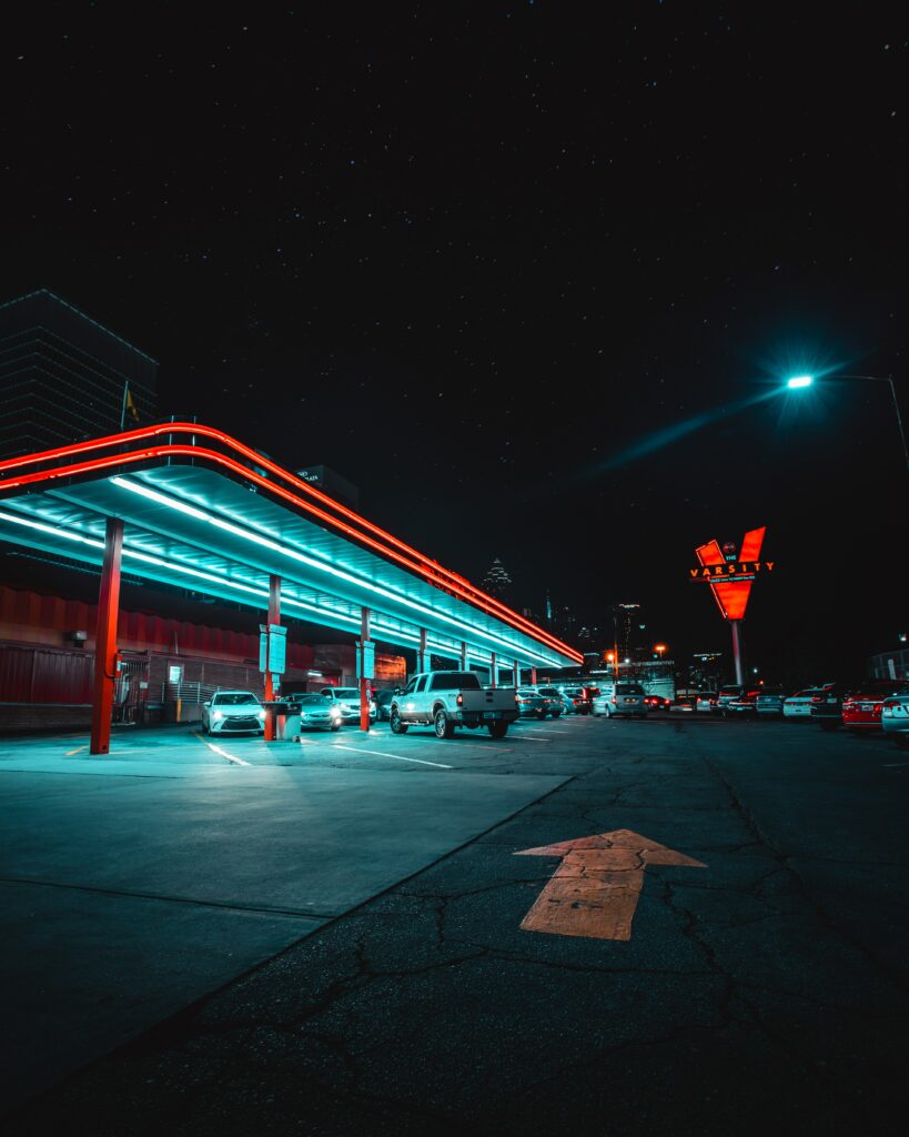 Futuristic Neon Night Scene: Cars Under Starry Sky Wallpaper