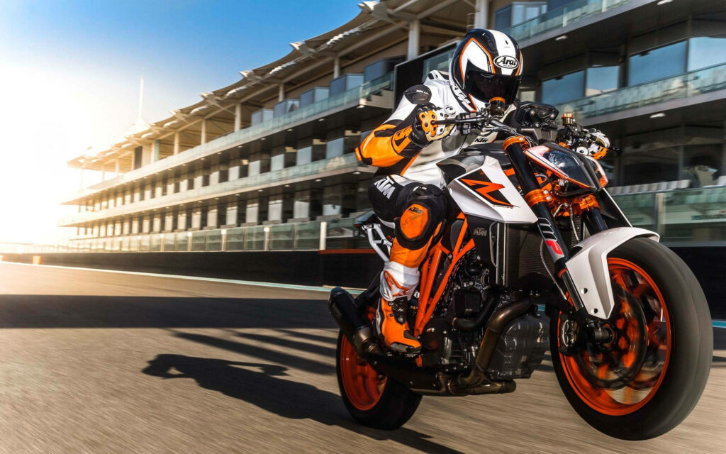 Vibrant Neon Orange Motorcycle Wallpaper: Thrilling Track Scene