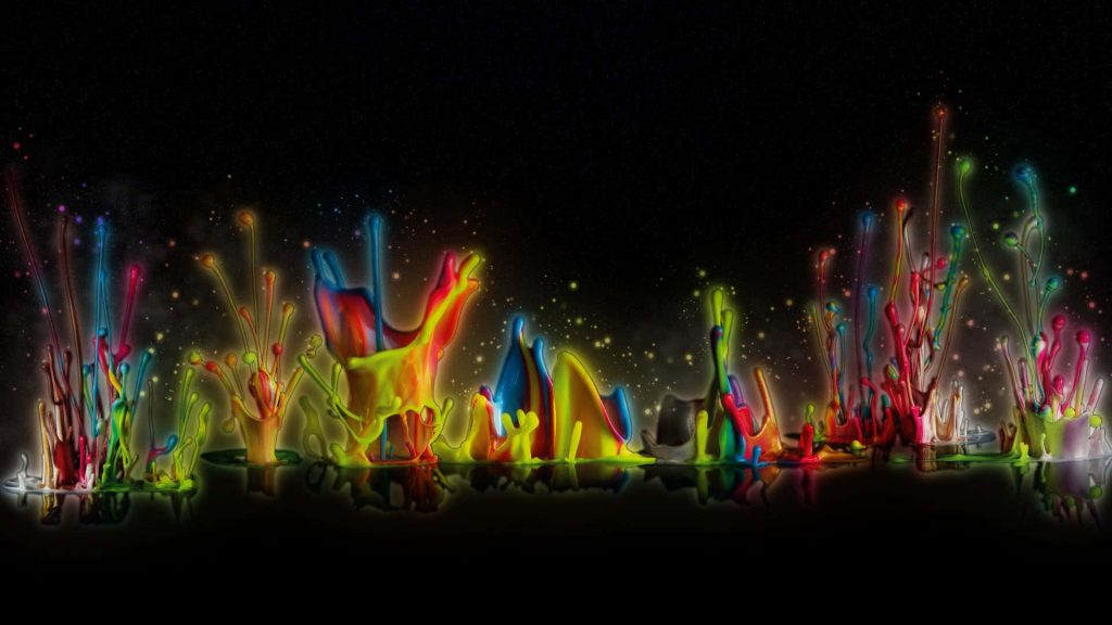 Vibrant colorful paint splashes on black background dynamic fluid art high-speed liquid wallpaper