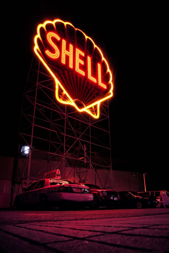 Vibrant Neon Shell Sign Wallpaper: Bold Red & Yellow Night Scene