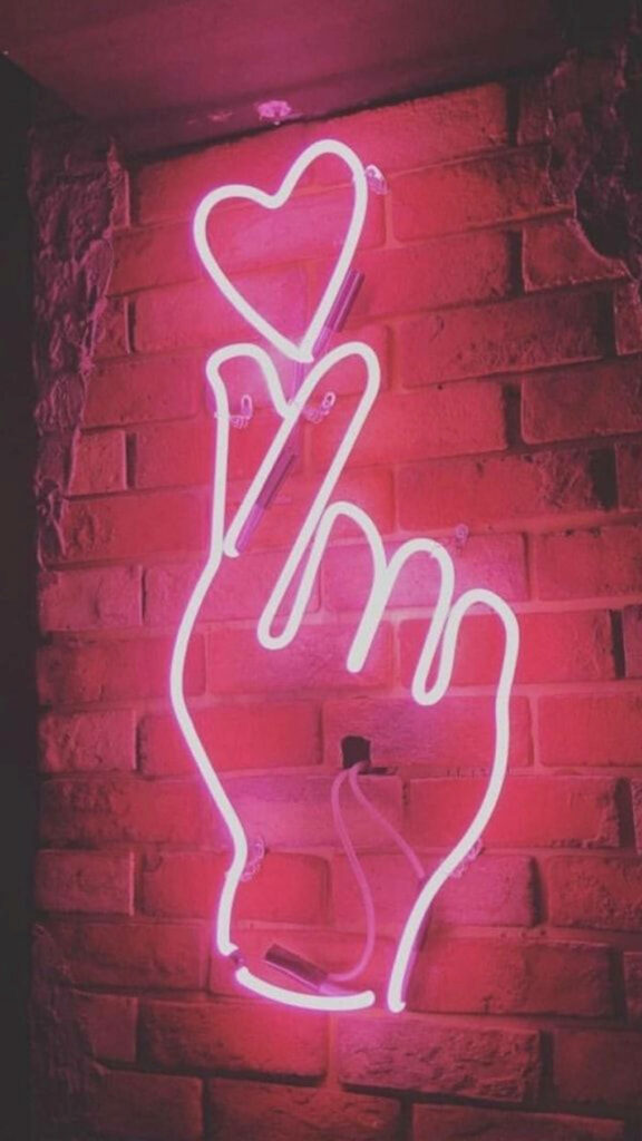 Trendy Neon Finger Heart Wallpaper Against Red Brick Background