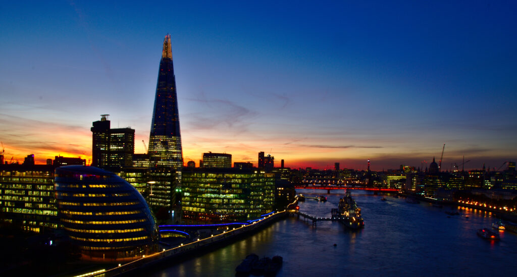 Vibrant Night Cityscape Wallpaper: Illuminated Tower & Serene Reflections