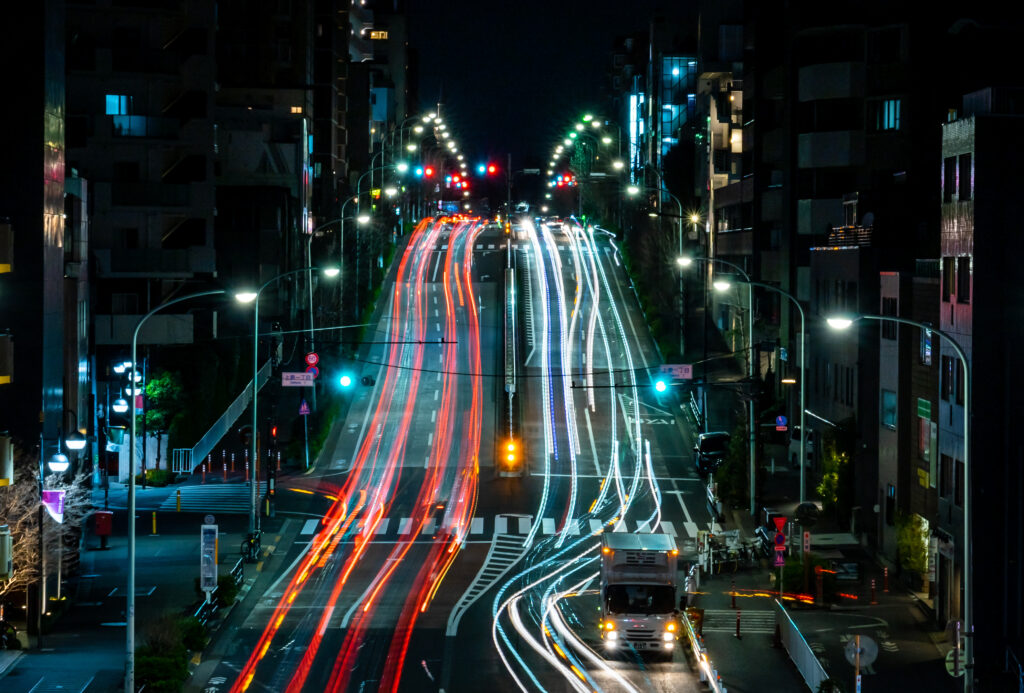 Vibrant Night Cityscape: Illuminated Road & Dynamic Light Trails Wallpaper
