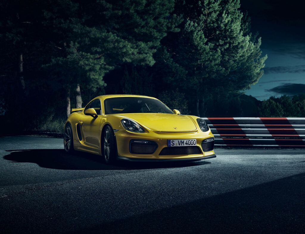 Vibrant Night Shot Wallpaper: Yellow Porsche Cayman Shines in Dark Alley