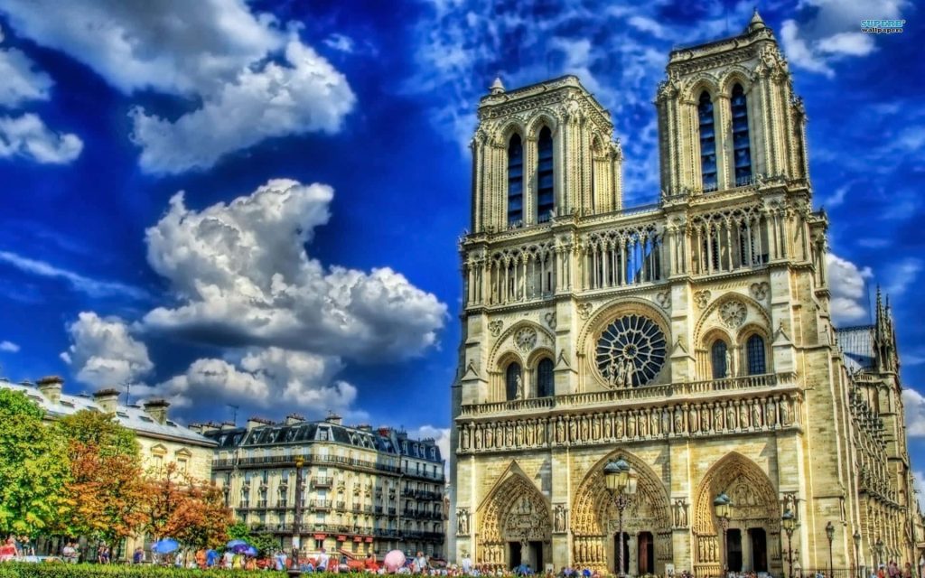 Notre-Dame Cathedral Paris Gothic facade and rose window under blue sky with tourists plaza Wallpaper