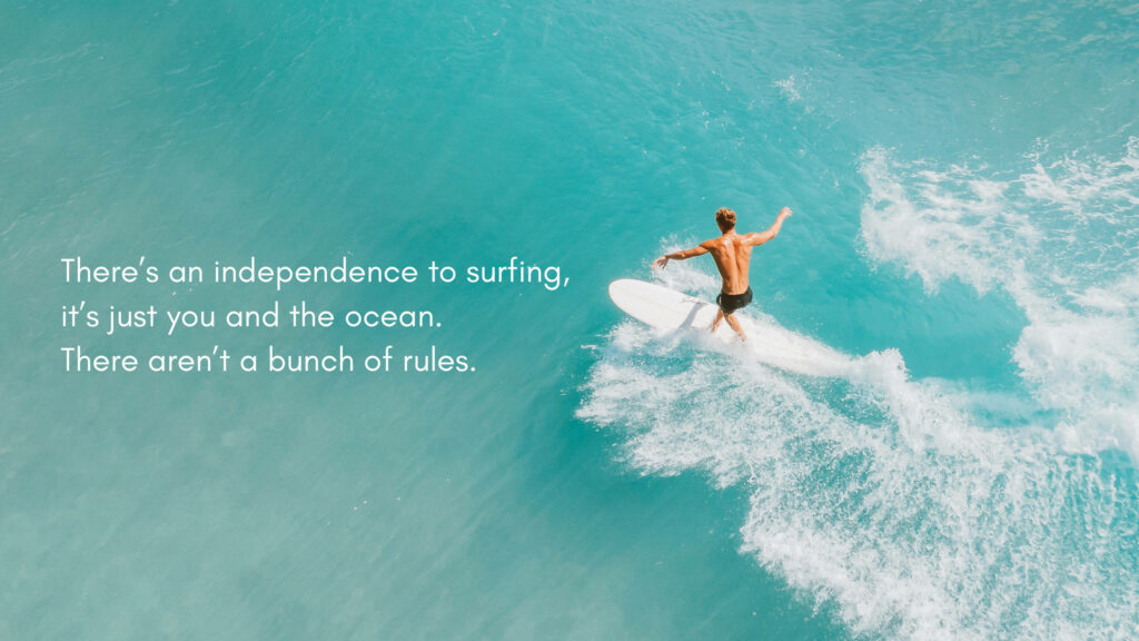 Surfer Embraces Freedom on Vibrant Waves Under Clear Skies Wallpaper