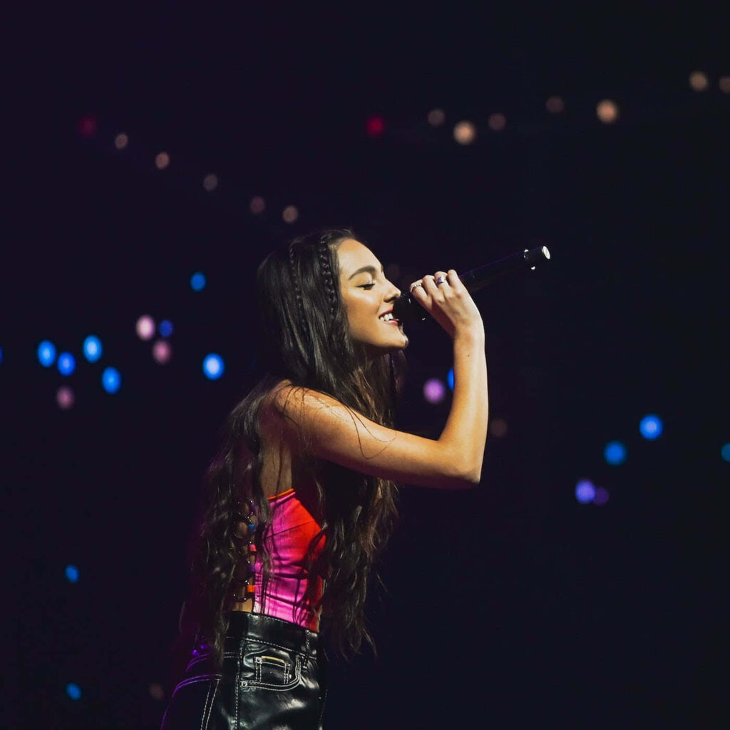 Vibrant Olivia Rodrigo Wallpaper: Passionate Stage Performance