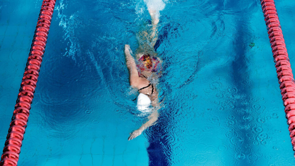Vibrant Olympic Swimmer Wallpaper: Dynamic Blue Pool Action