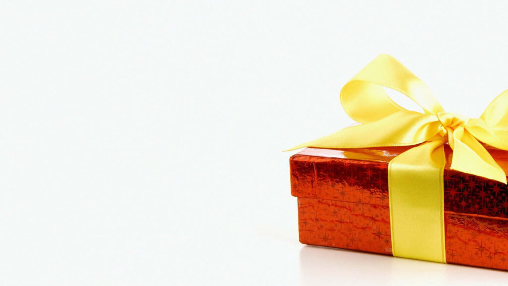 Vibrant orange gift box with shiny yellow ribbon on white background celebrating joy and festivity Wallpaper