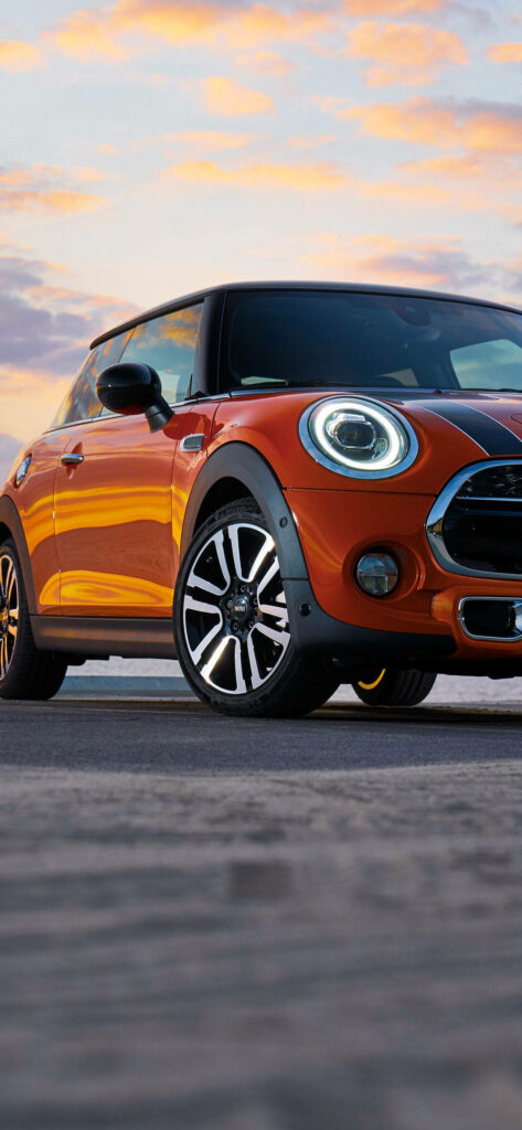 Vibrant Orange Mini Cooper Wallpaper Against Sunset Sky