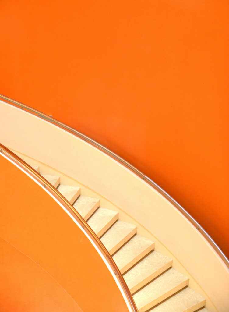 Minimalist Orange Wallpaper with Curved Staircase - Modern Design