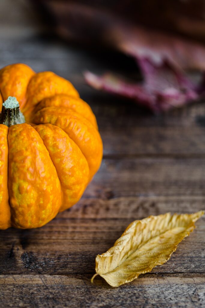 Cozy Autumn Wallpaper: Vibrant Pumpkin & Rustic Table Scene