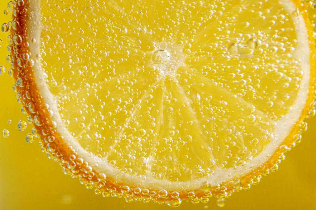 Vibrant Orange Slice in Liquid with Bubbles - Refreshing Wallpaper