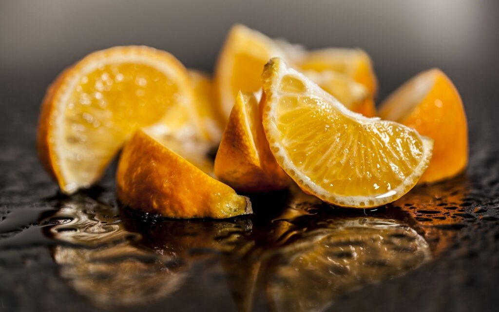 Vibrant Citrus Wallpaper: Juicy Orange Slices on Reflective Surface