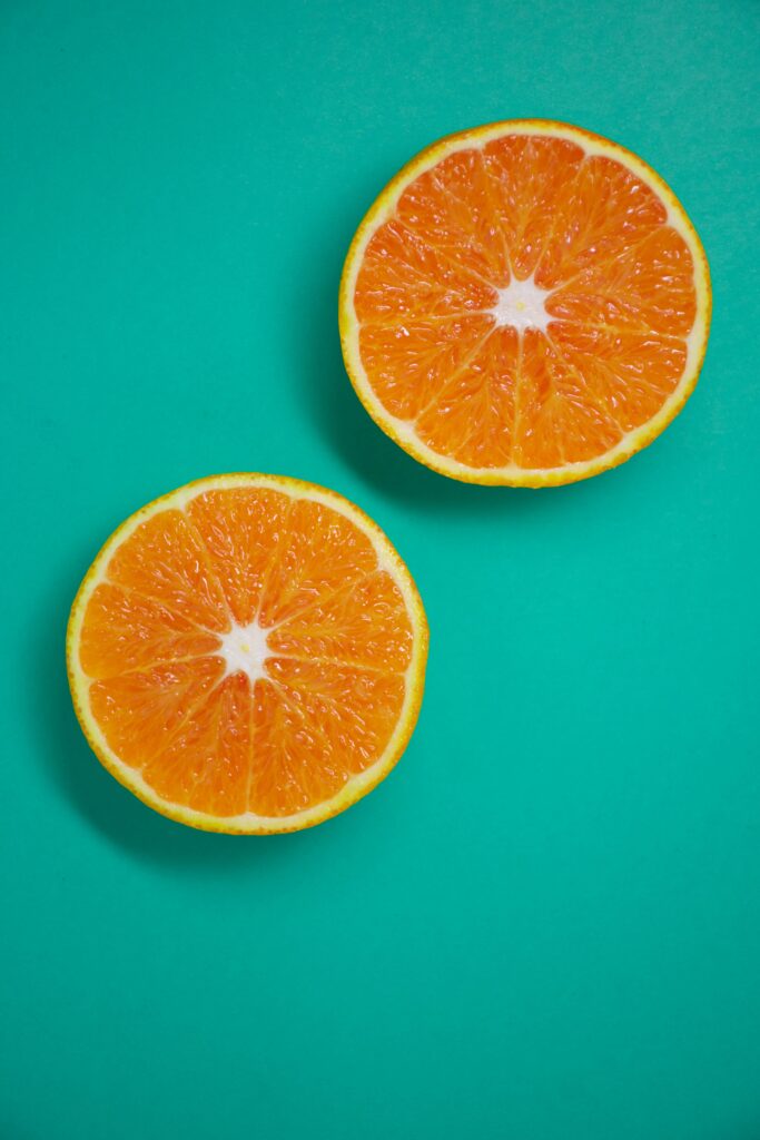 Juicy Orange Slices Wallpaper: Bright Teal Citrus Background
