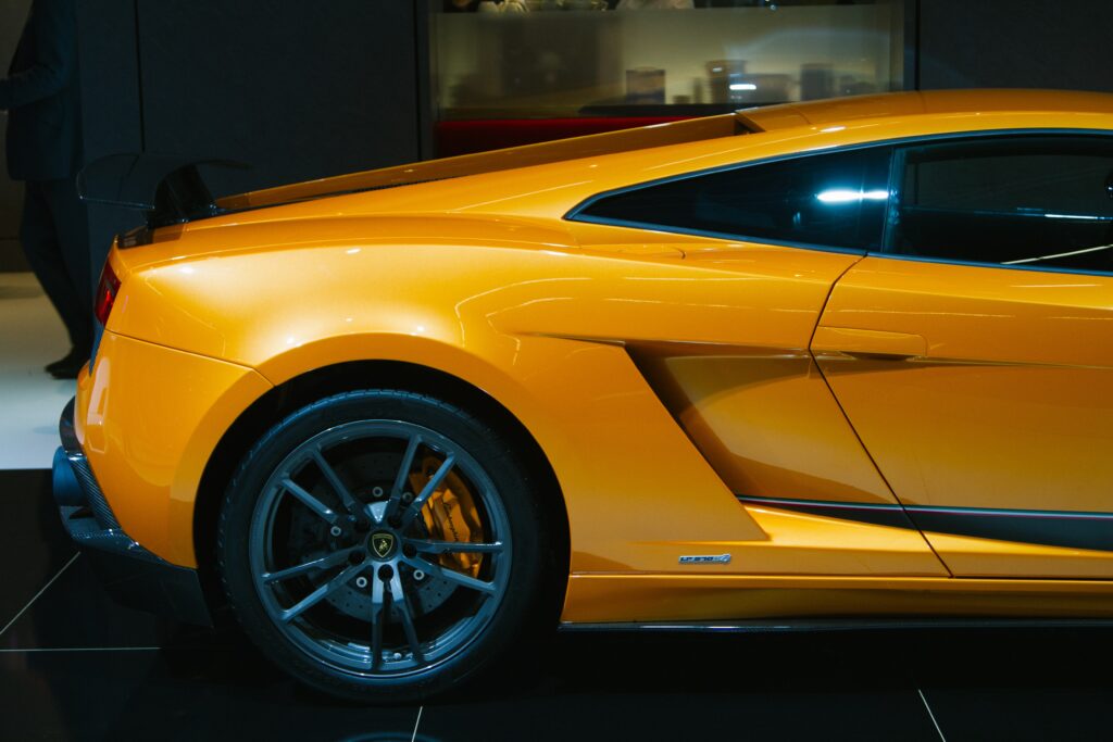 Vibrant Orange Sports Car Side View: Aerodynamic Design & Power Wallpaper