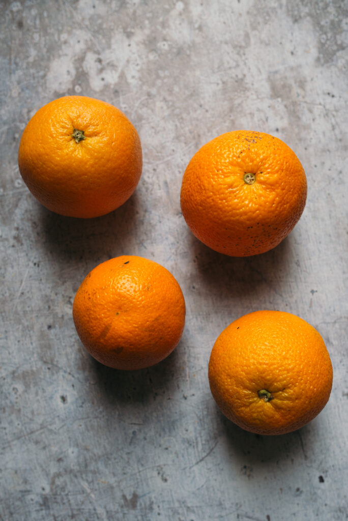 Fresh Citrus Wallpaper: Four Vibrant Oranges on Textured Surface