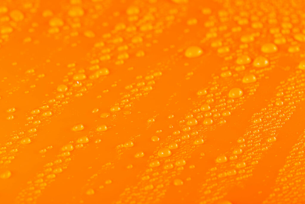 Vibrant Orange Wallpaper: Macro Water Droplets on Smooth Surface