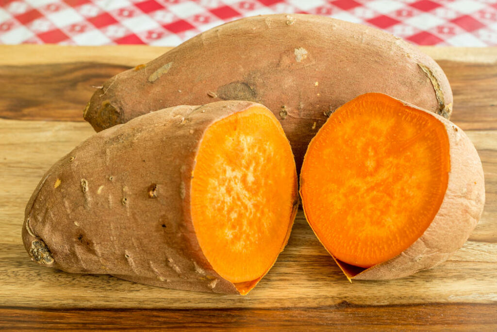 Vibrant Orange Yam Wallpaper: Rustic Wood & Fresh Texture