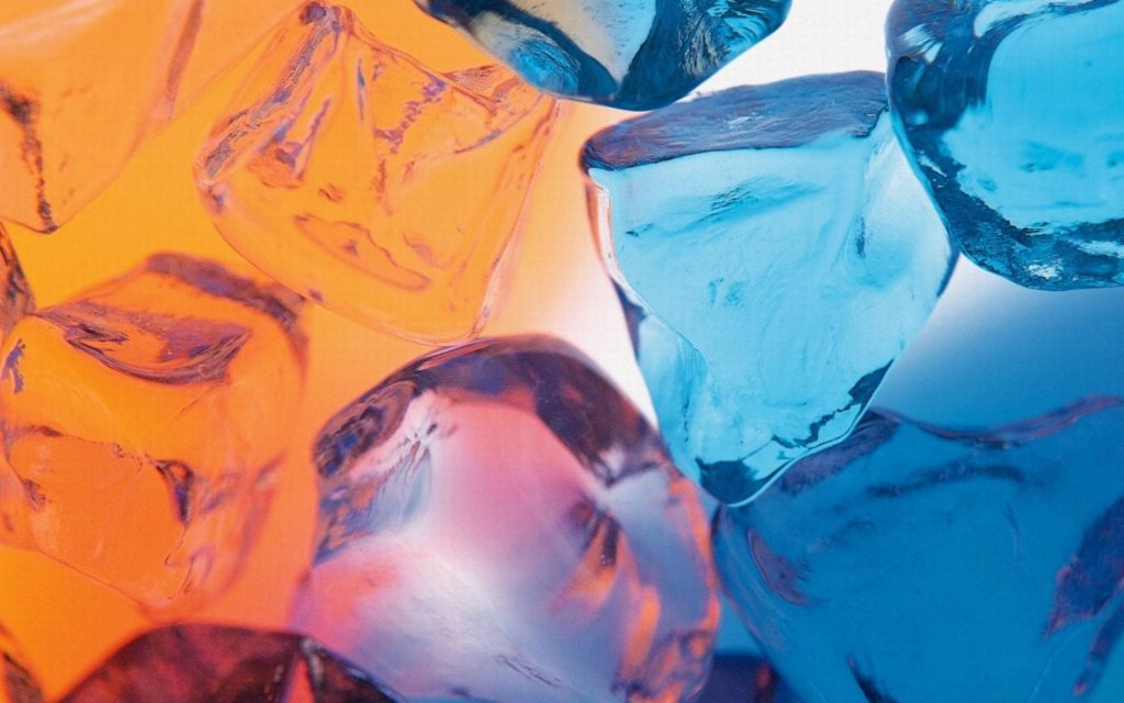 Abstract macro image of crystalline ice cubes in vibrant orange and electric blue lighting background Wallpaper