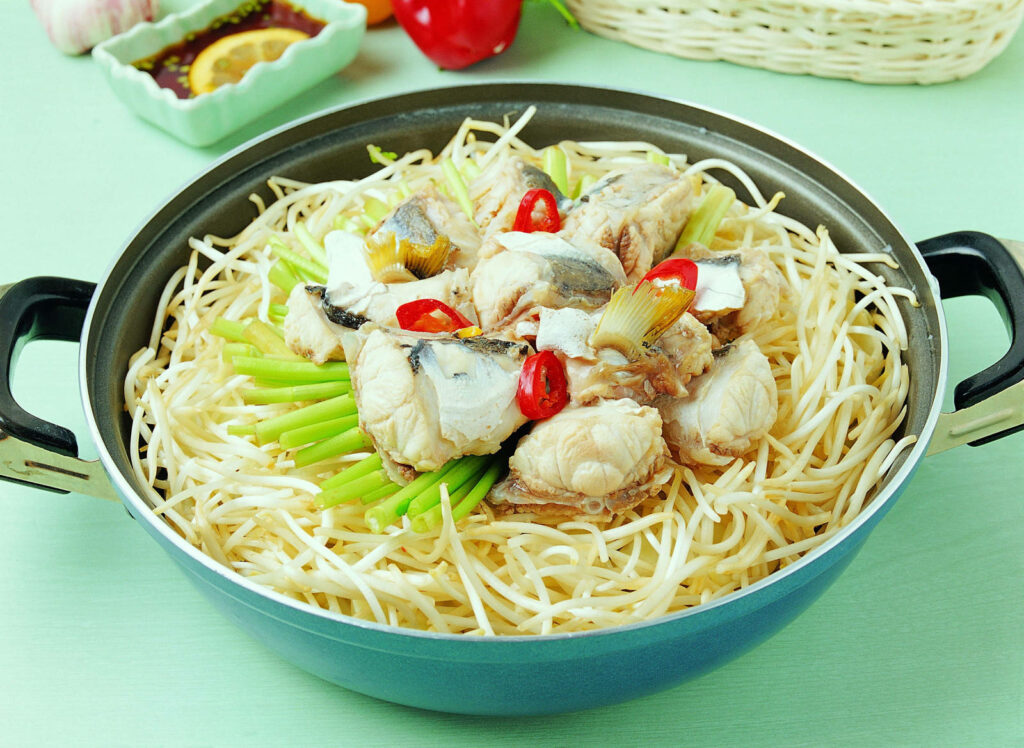 Vibrant Pad Thai in Cooking Pot: Colorful Rice Noodles & Fish Dish Wallpaper