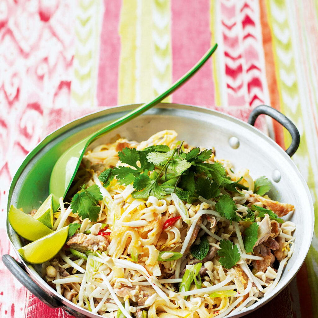 Vibrant Pad Thai Wallpaper: Colorful Cooking Pot & Fresh Garnishes