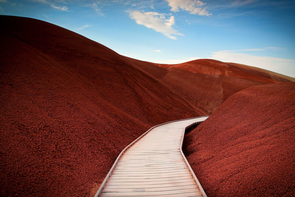 Painted red hills near Mitchell Oregon with wooden boardwalk and vibrant mars-like landscape Wallpaper