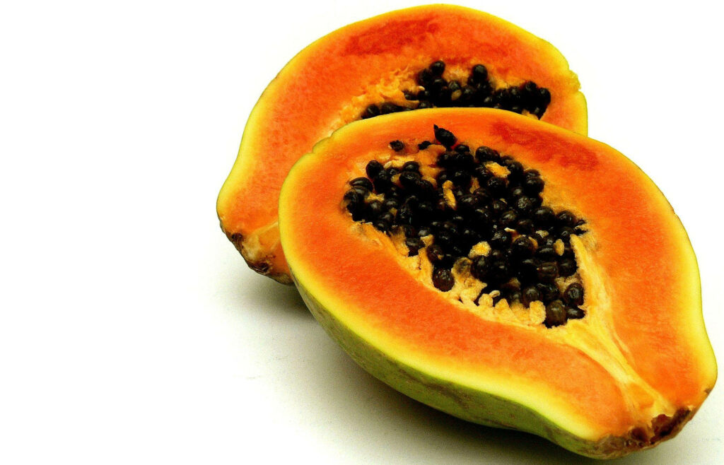 Fresh Papaya Wallpaper: Vibrant Orange & Black Seeds on White Background