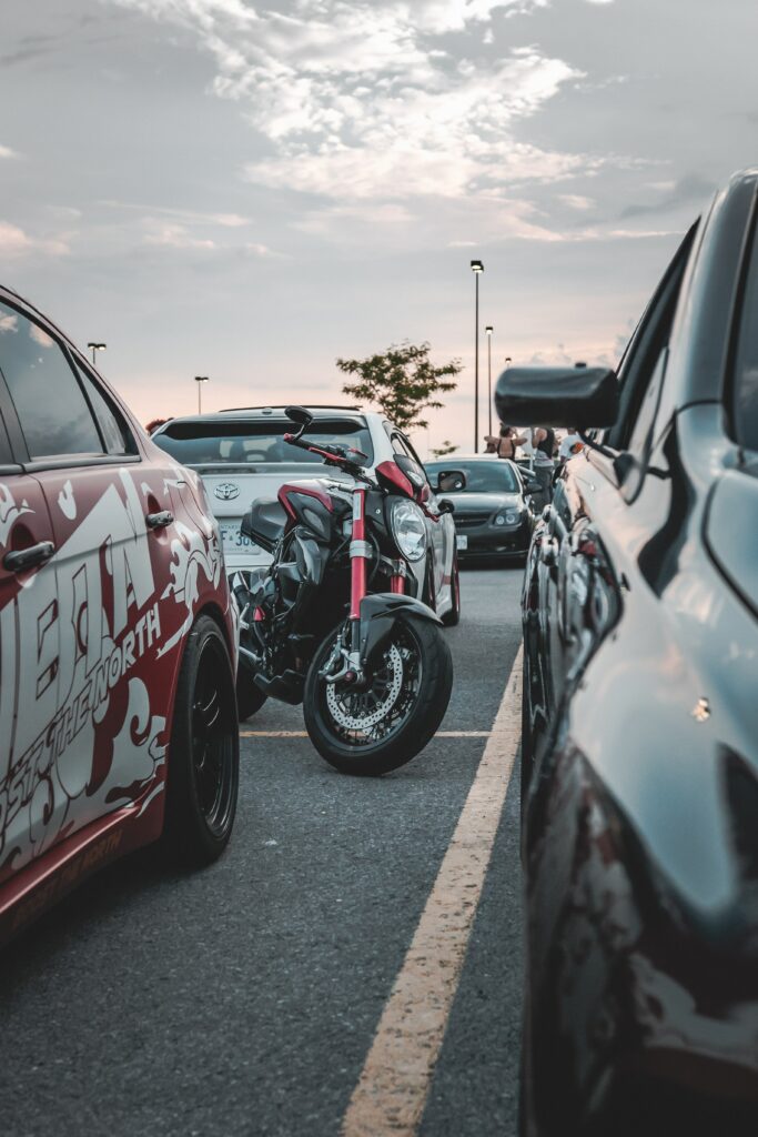 Dynamic Sunset Parking Lot Wallpaper with Motorcycle and Cars