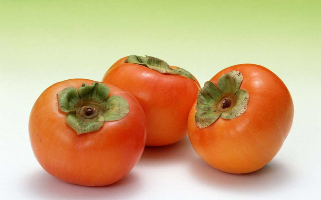 Vibrant Persimmon Wallpaper: Ripe Fruits & Green Gradient Background