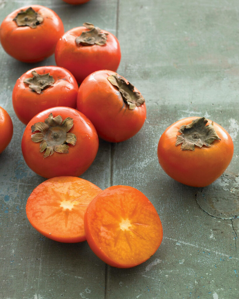 Vibrant Persimmon Wallpaper: Ripe Fruits on Rustic Table Background