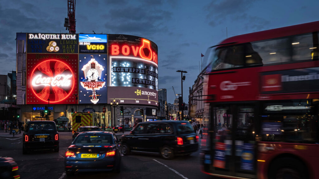 Vibrant Piccadilly Circus Evening View: Traffic & Iconic Red Bus Wallpaper