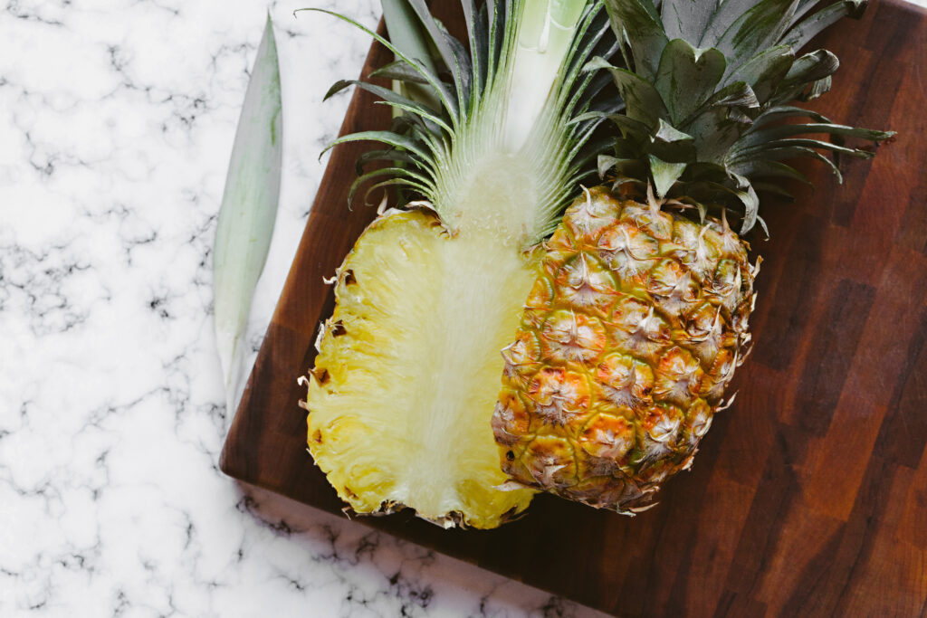 Vibrant Pineapple Half on Wood: Fresh Wallpaper Background